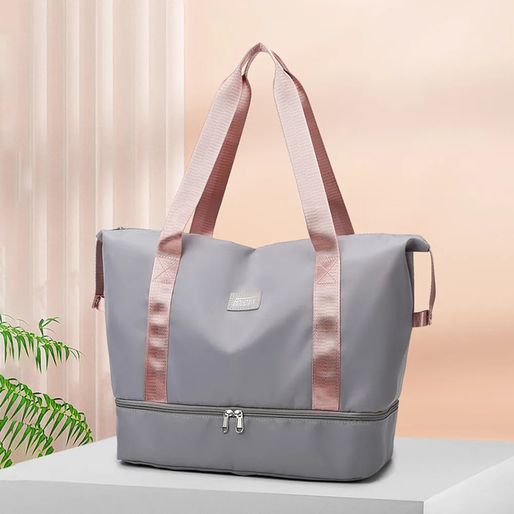 Light gray tote bag with pink handles and dual zippered compartments, set against a soft indoor background. Chic and practical—ideal for gym, travel, or daily use.