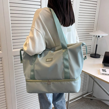 A lady hanging a light blue duffel bags with zippered top and bottom compartments, set against a pastel pink background. Stylish and functional—perfect for travel or gym use.