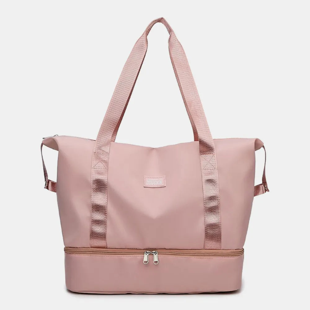 Pink travel bag with dual shoulder straps and a zippered bottom compartment, featuring a sleek design and front patch. Modern and practical—ideal for gym, travel, or daily use.