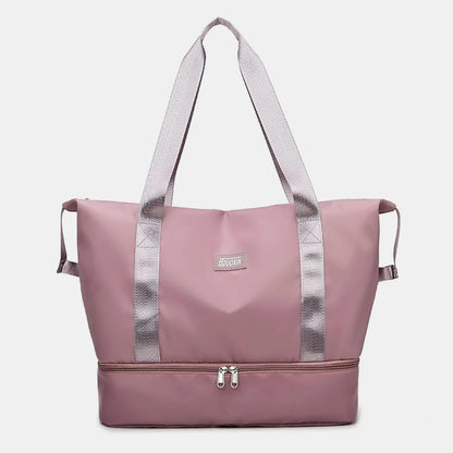 Pink travel bag with light gray straps and a zippered bottom compartment, set against a white backdrop with geometric decor. Sleek and functional—great for gym, travel, or daily use.