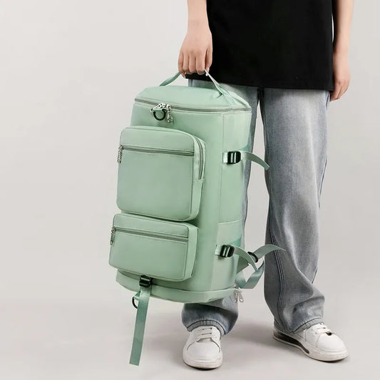 A man holding a large mint green backpack with multiple zippered compartments and side straps. Functional and stylish—great for travel or outdoor use.