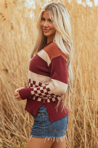 Woman models a checkered color block sweater, featuring a crew neck, perfect for a cozy and stylish look, side view