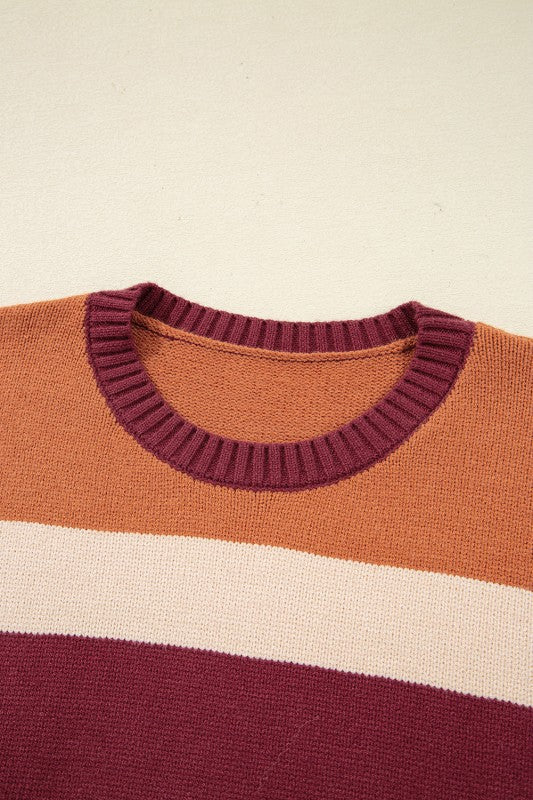 Checkered color block sweater featuring warm tones like rust, burgundy, and cream, with a classic crew neck and ribbed cuffs, close up view.