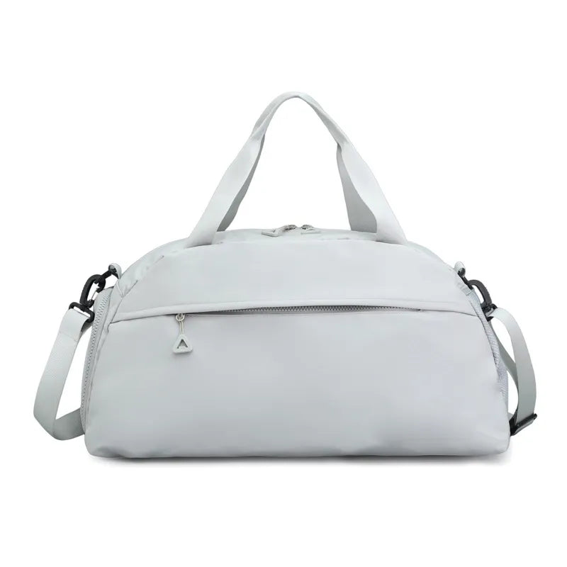 Light gray duffel bag with a clean, minimalist design, featuring short handles, a long adjustable shoulder strap, and a front zippered pocket with a triangular pull. Sleek and functional—ideal for gym, travel, or everyday use.