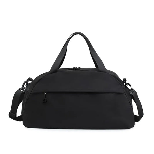 Black duffel bag with a minimalist design, featuring short handles and a long adjustable shoulder strap with metal clasps. Includes a front zippered pocket and a durable main compartment—sleek, practical, and perfect for everyday, gym, or travel use.