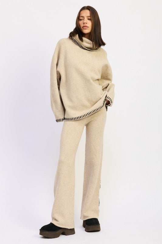 a landy standing wearing an oversized Turtle neck sweater
