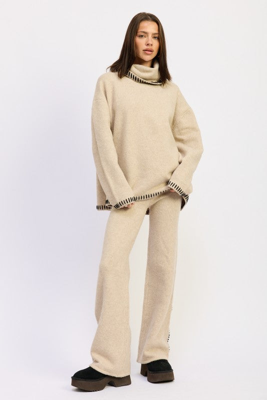 a lady standing and pocket wearing an oversized turtle neck sweater