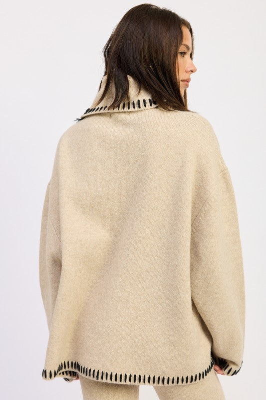 a lady turning back display an oversized turtle neck sweater in a fashion style