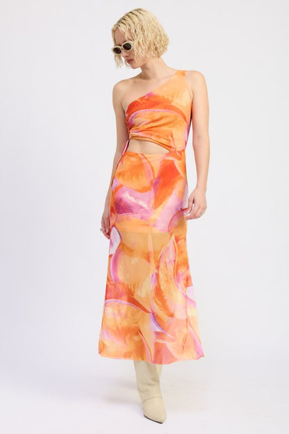 A lady wearing a one-shoulder maxi dress with an abstract orange, pink, and yellow print. 