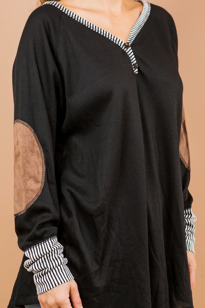 A classic tunic silhouette elevated by button detailing and patch embellishments.