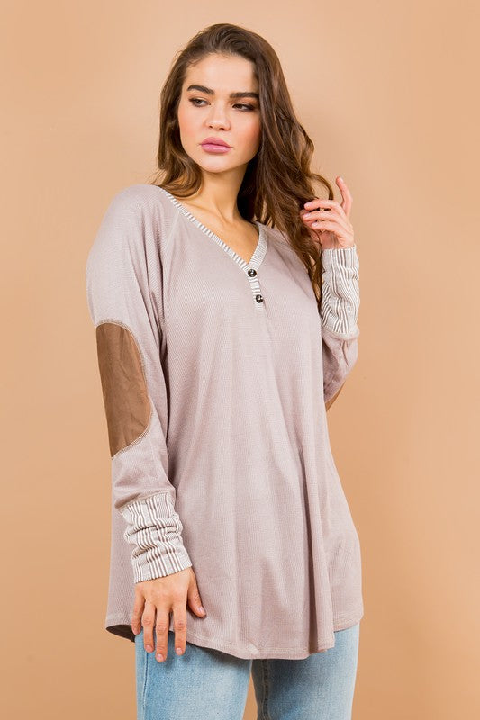 Contrasted sleeves and patchwork detailing give this tunic depth and charm.