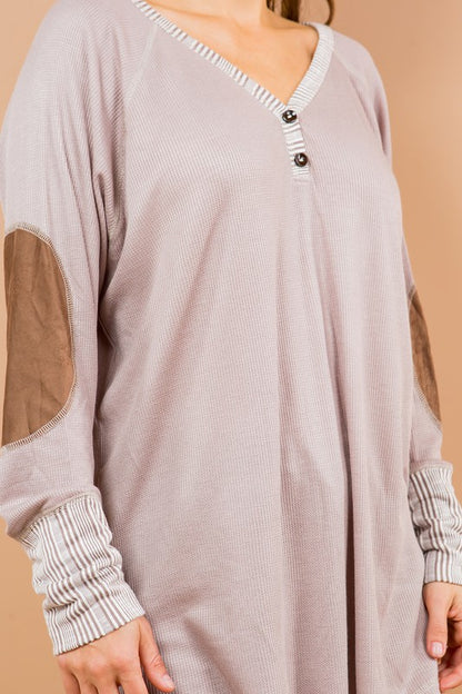 A stylish oversized tunic featuring structural details like elbow patches and buttons.