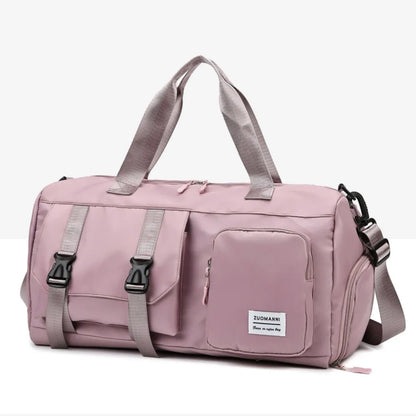 Pink duffel bag with short handles and an adjustable shoulder strap, featuring a flap pocket with black buckles and a zippered front pocket.  Durable and stylish—ideal for gym or travel.