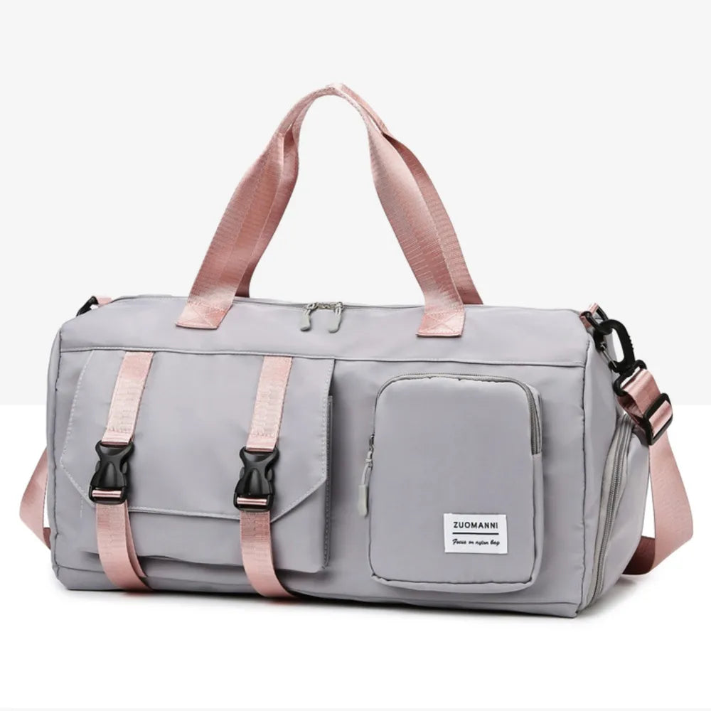 Light gray duffel bag with pink handles and shoulder strap, featuring a front zip pocket and smooth, slightly glossy material. Modern and functional—ideal for gym, travel, or everyday use.