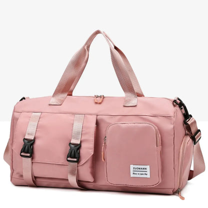 Pink duffel bag with short handles, adjustable shoulder strap, front buckle-strap pocket, and zippered compartment. Durable and stylish—ideal for gym or travel.