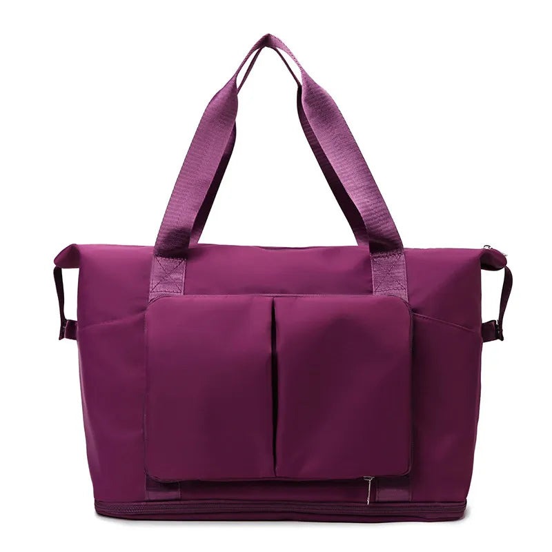 Purple tote-style bag with dual shoulder straps, front vertical pockets, and a bottom zip compartment. Made from durable fabric with side loops for added functionality—ideal for gym, travel, or everyday use.
