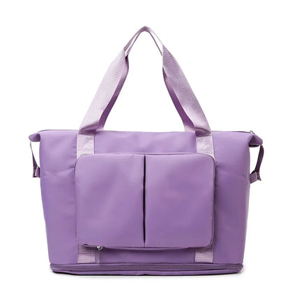 Purple tote bag with light purple handles, featuring a zippered main compartment, dual front pockets, and a bottom zip section. Sleek and functional—ideal for gym, travel, or daily use.