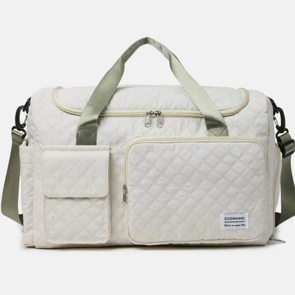 White quilted duffel bag with light green handles and shoulder strap, featuring a zippered main compartment, front zip pocket, and flap pocket.