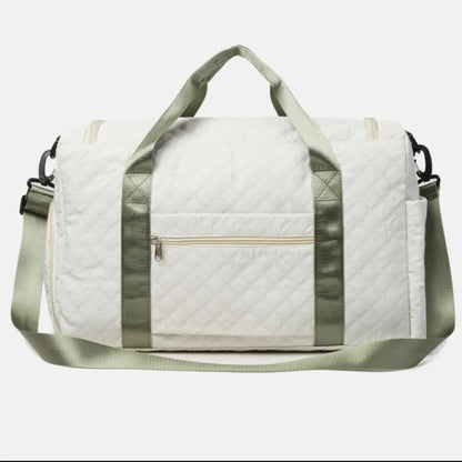 White quilted duffel bag with light green straps, featuring a front zip pocket, side pocket, and adjustable shoulder strap. Clean, modern design—ideal for travel or gym use.