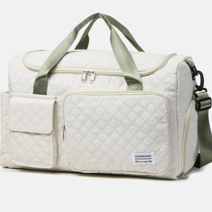 White quilted duffel bag with green straps, featuring a zip pocket and flap pocket on the front. Stylish and functional for travel or gym use.
