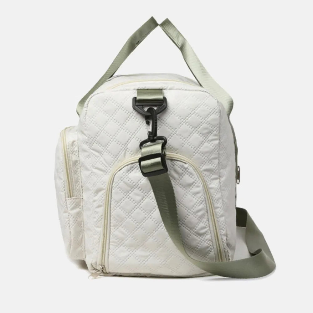 White quilted duffel bag with green straps, featuring a zip pocket and flap pocket on the front. Stylish and functional for travel or gym use.