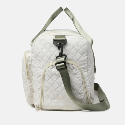 White quilted duffel bag with green straps, featuring a zip pocket and flap pocket on the front. Stylish and functional for travel or gym use.