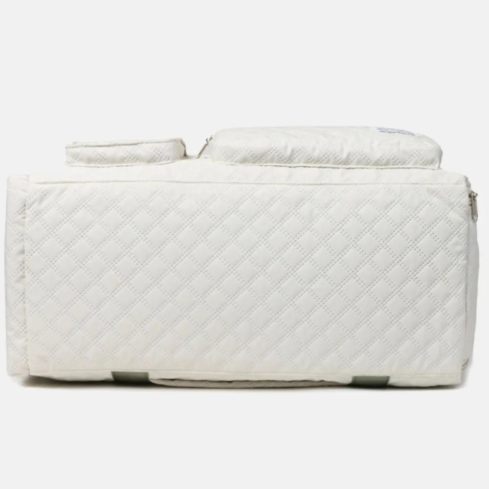 White quilted duffel bag with green straps, featuring a zip pocket and flap pocket on the front. Stylish and functional for travel or gym use.