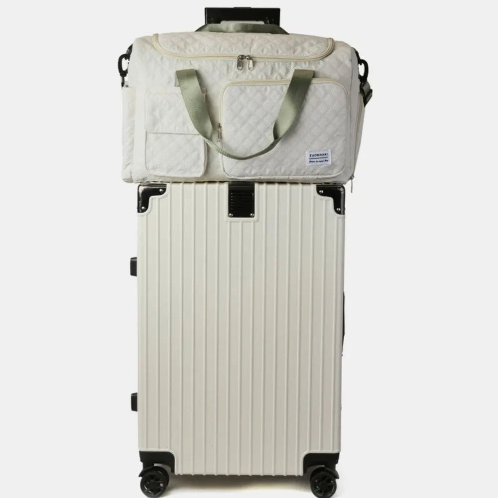 Compact travel setup with a ribbed hard-shell suitcase and a quilted duffel bag featuring green handles and shoulder strap.