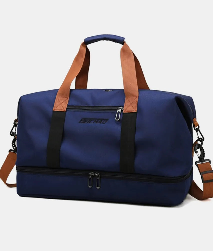 Navy blue duffel bag with brown handles and black straps, featuring top and bottom zippered compartments and a front label. Durable and stylish—ideal for gym, travel, or everyday use.