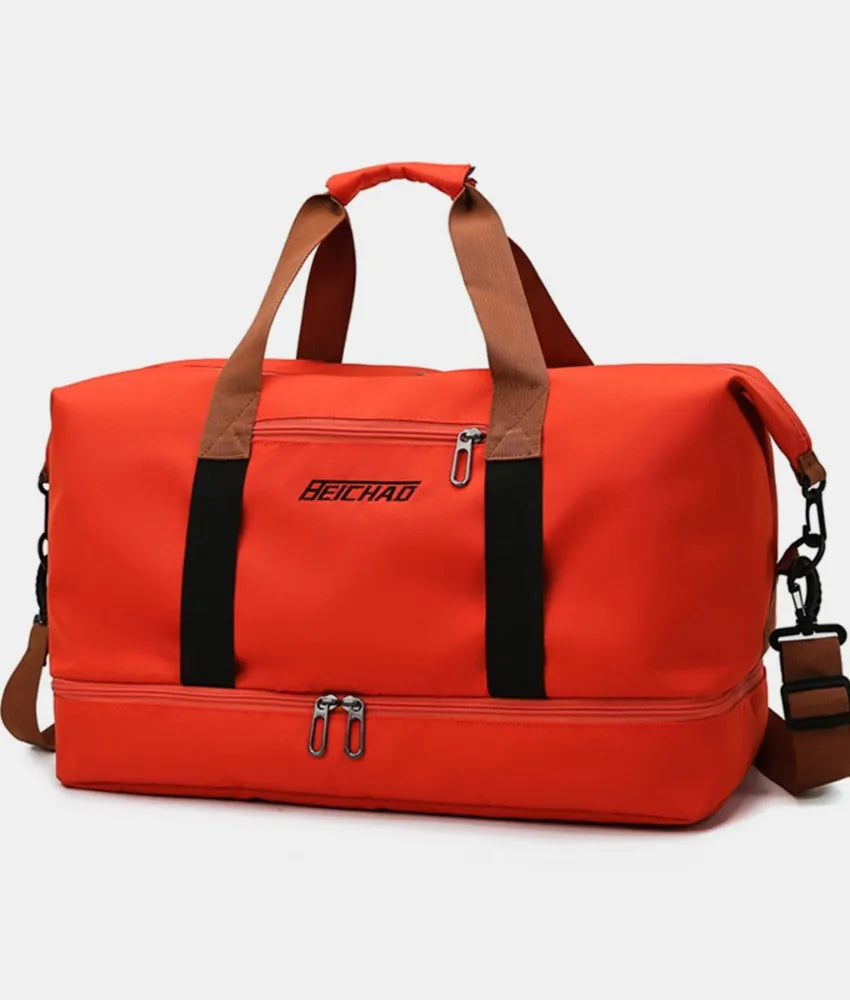 Bright red duffel bag with brown handles and black straps, featuring top and bottom zippered compartments and a front label. Bold, durable, and practical—perfect for gym, travel, or everyday use.