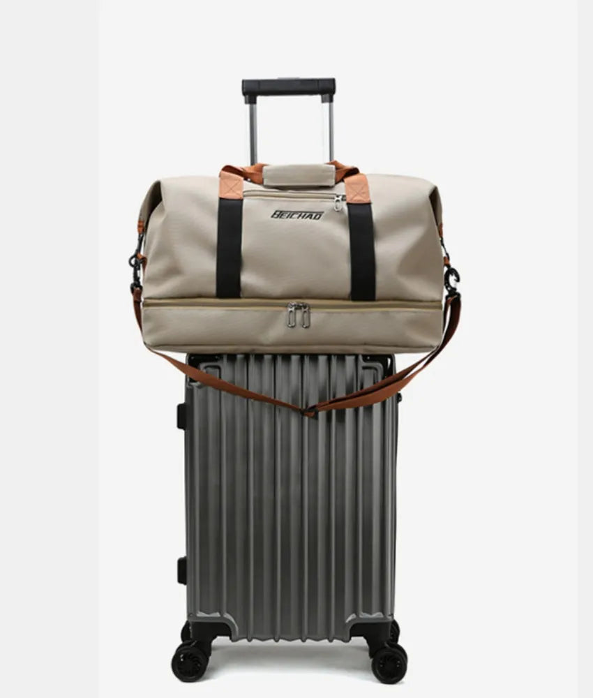 Beige duffel bag with brown accents and a shoulder strap, securely placed on top of a silver hard-shell suitcase with a retractable handle. Compact and convenient setup—perfect for organized travel.