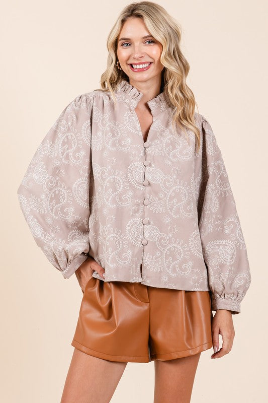 This plus-size blouse features a paisley eyelet lace pattern with elegant button-up styling.