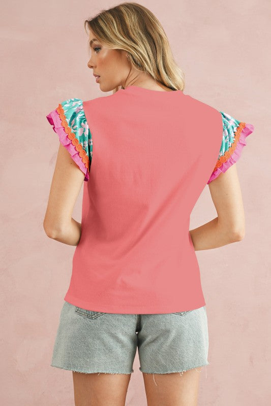 Features delicate floral appliques, and rick-rack detailing on the sleeves. 