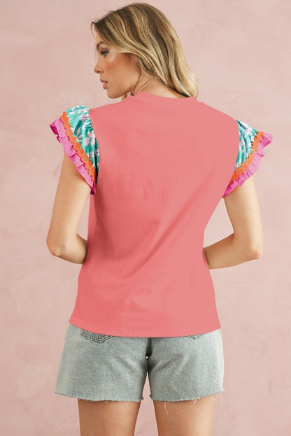 Features delicate floral appliques, and rick-rack detailing on the sleeves. 