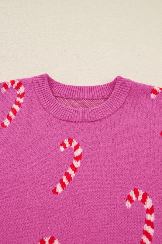 Pink candy cane patterned sweater displayed against white background