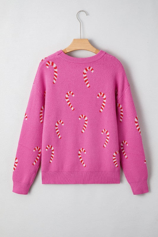Pink candy cane patterned sweater displayed on hanger against white background