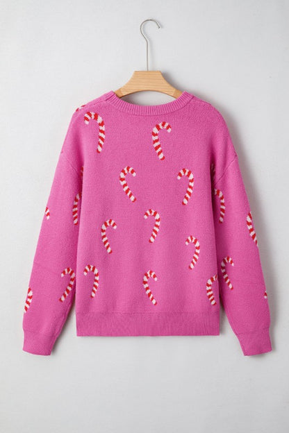 Pink candy cane patterned sweater displayed on hanger against white background