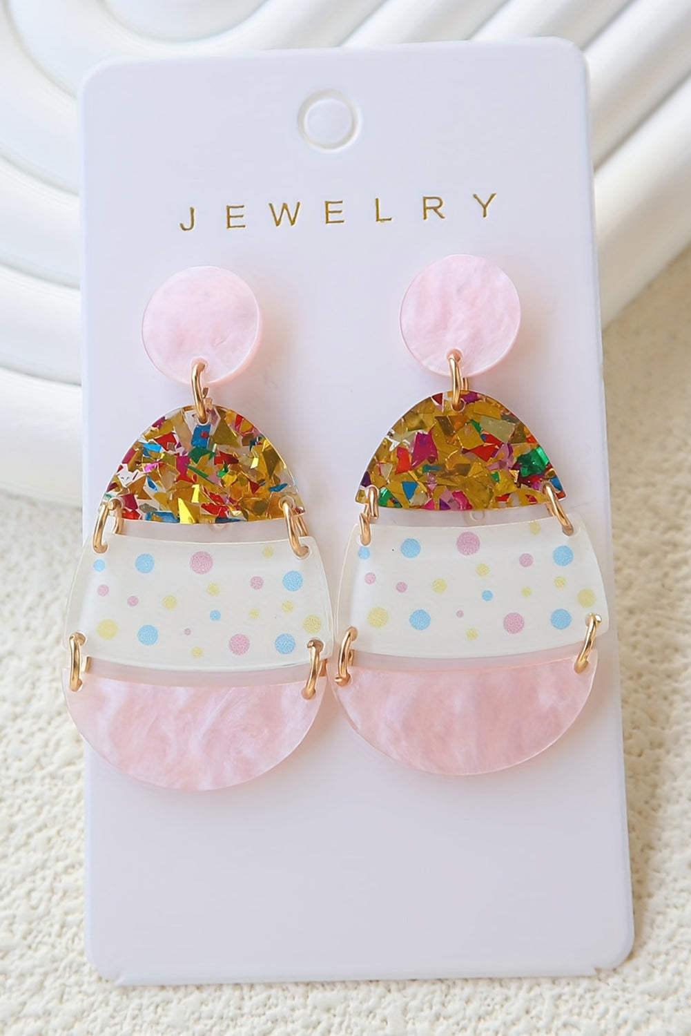 Hop into spring with a little sparkle. These adorable Easter egg-shaped drop earrings are the perfect way to celebrate the season in style. Featuring a soft pink hue and whimsical printed patterns, they’re sweet, festive, and totally charming.