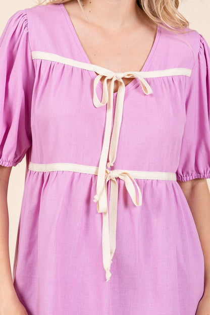 Relaxed fit meets structured detail with piped seams at the neckline and hem.