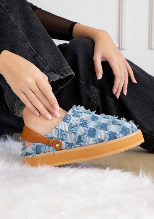 Denim patchwork slip-on shoes with frayed edges, rounded toe, platform sole with lug tread, and pull-tab at heel counter