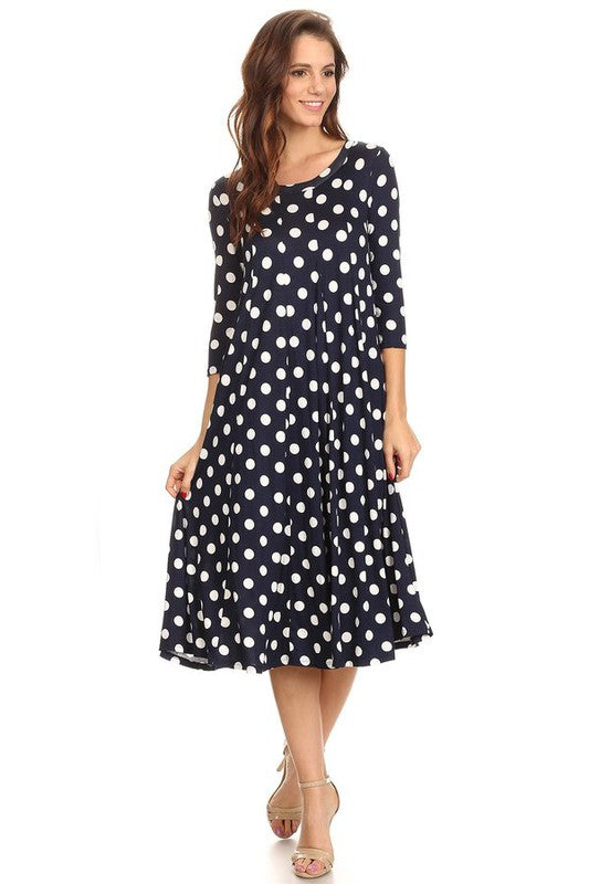 Woman wearing a paneled polka dot A-line midi dress with ¾ sleeves.