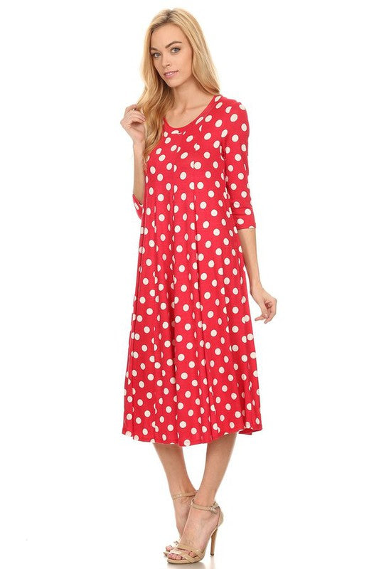 Woman wearing a paneled polka dot A-line midi dress with ¾ sleeves.