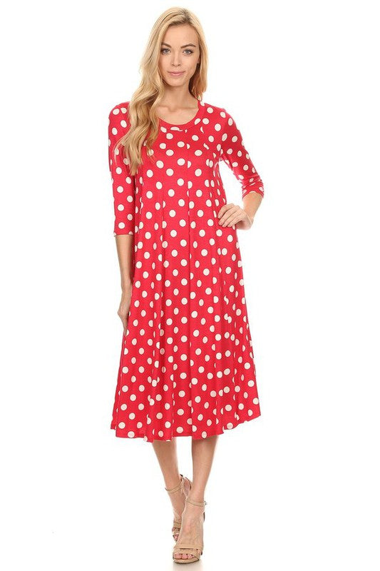 Woman wearing a paneled polka dot A-line midi dress with ¾ sleeves.