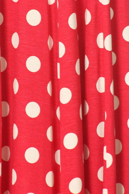 Woman wearing a paneled polka dot A-line midi dress with ¾ sleeves.
