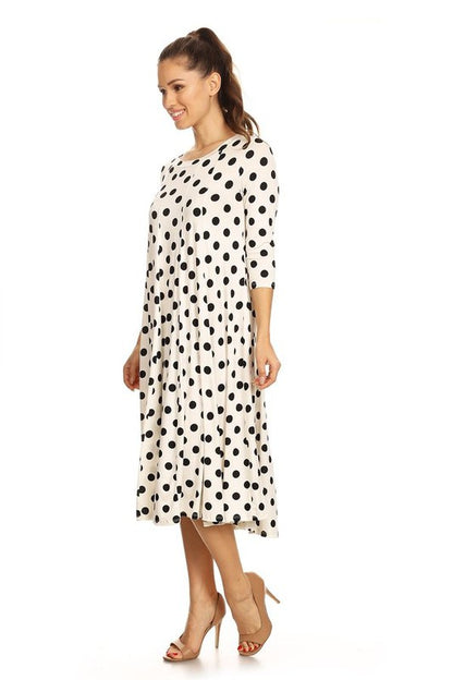 Woman wearing a paneled polka dot A-line midi dress with ¾ sleeves.