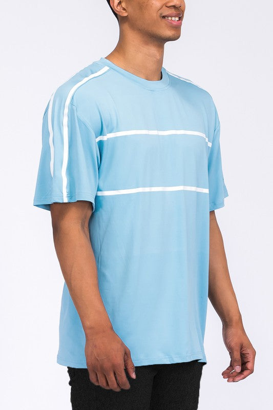 A man wears a t-shirt with two horizontal chest stripes and one vertical stripe on the left shoulder.