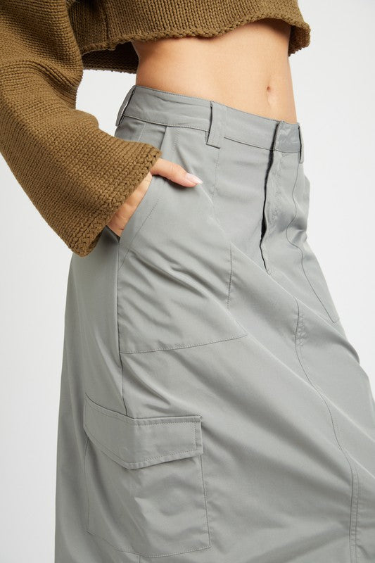 Person wearing gray cargo pants with a brown cropped sweater on a white background