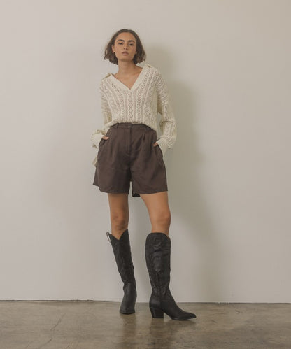 Knee-high western boots with embroidered stitching, pointed toe, stacked block heel, and side zipper closure.
