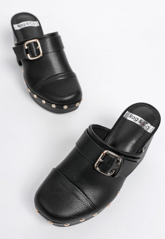 Black clogs with buckles and studded details on a white background