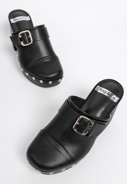 Black clogs with buckles and studded details on a white background